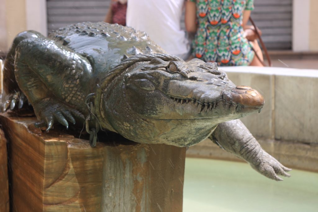 Krokodil aus Stein auf einem Brunnen