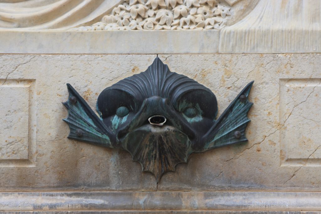 Drachenkopf als Wasserspeier eines Brunnen
