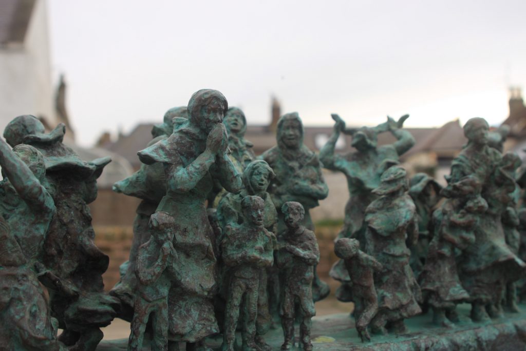 Bronzefiguren auf einer Bronzemauer