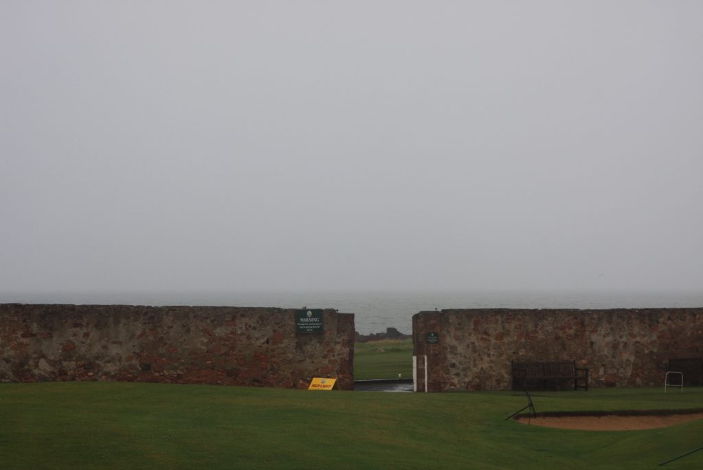 Blick über eine Steinmauer auf das Meer