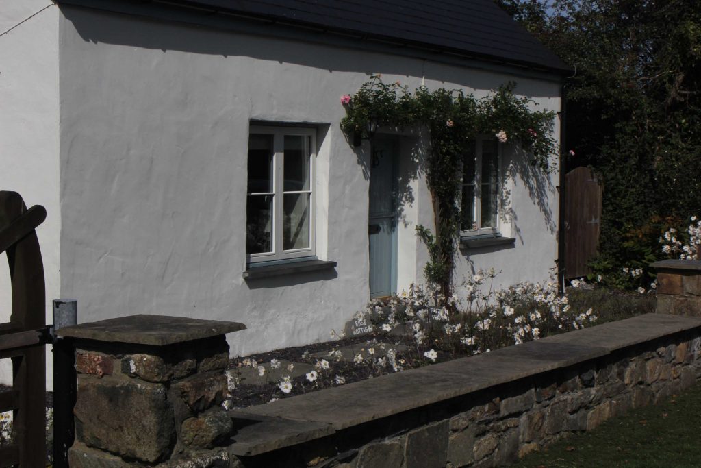 Weißes Cottage mit Kletterrosen