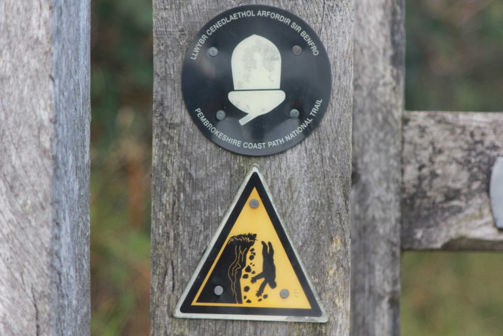 Eichel Markierung für den Coast Path und Warnhinweis Absturzgefahr