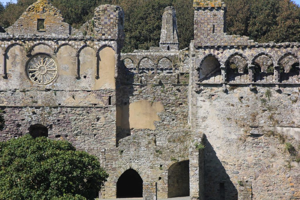 Ruine des Bischofspalast Saint Davids mit Steinrosette und Arkadenbogen